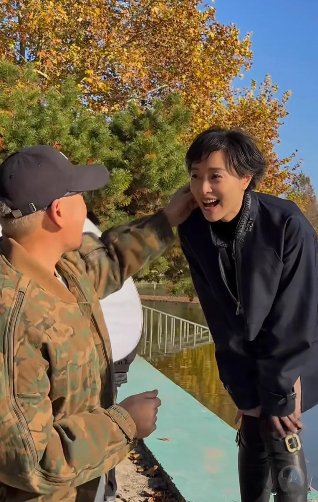 演员吴越现身上海一公园拍杂志封面。她穿着一身墨蓝色裙装，脚踩长靴，留着一头短发