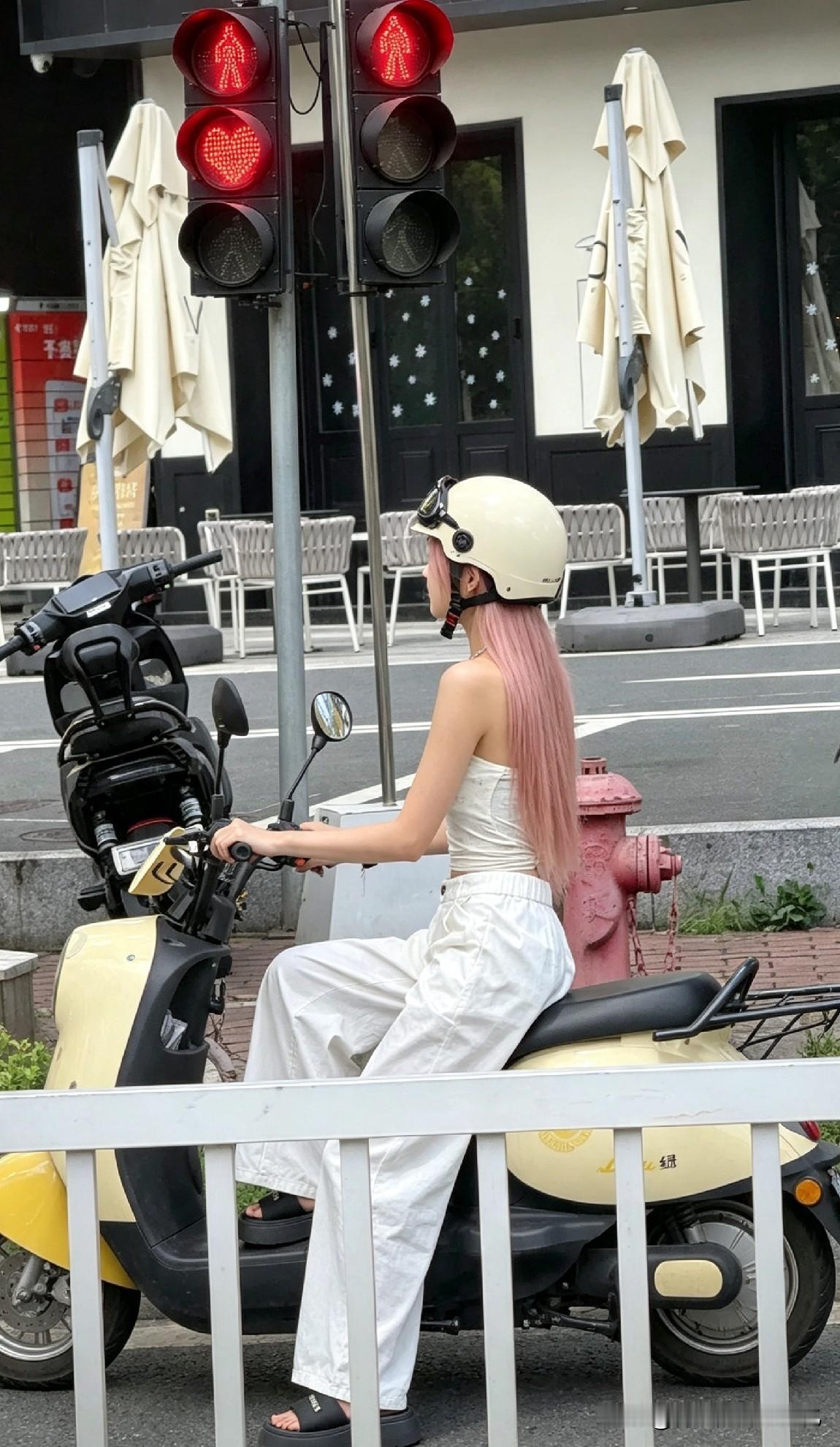 粉发女孩等红灯被拍，下一秒动作让路人愣住她坐在电动车上。粉发垂到腰。