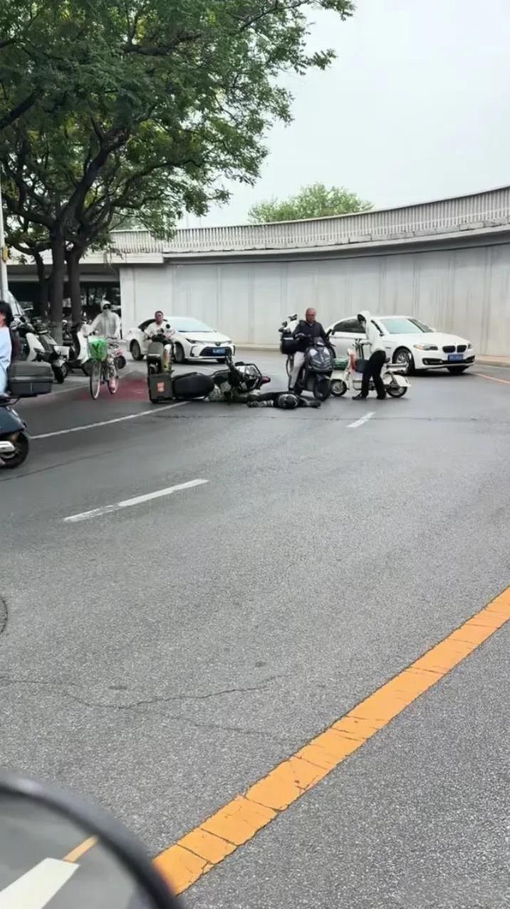 一帮大老爷们，还不如一位女子！北京街头，一名骑手摔倒了，开车的看到了，骑摩托车的