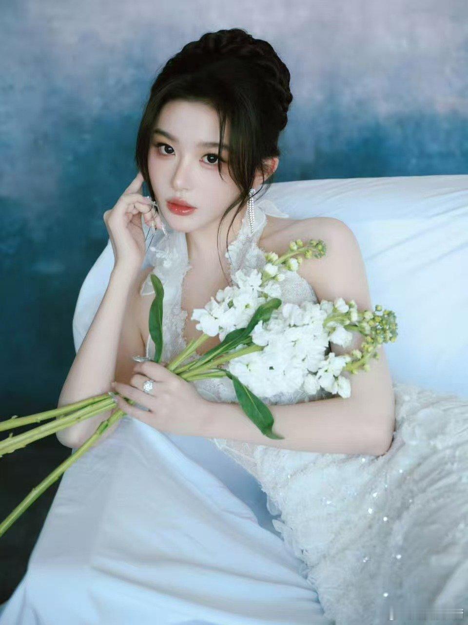 孔雪儿白裙缀满星子碎钻，转身时裙摆掀起月光潮汐。指尖轻拈郁金香，花瓣颤成春的私语