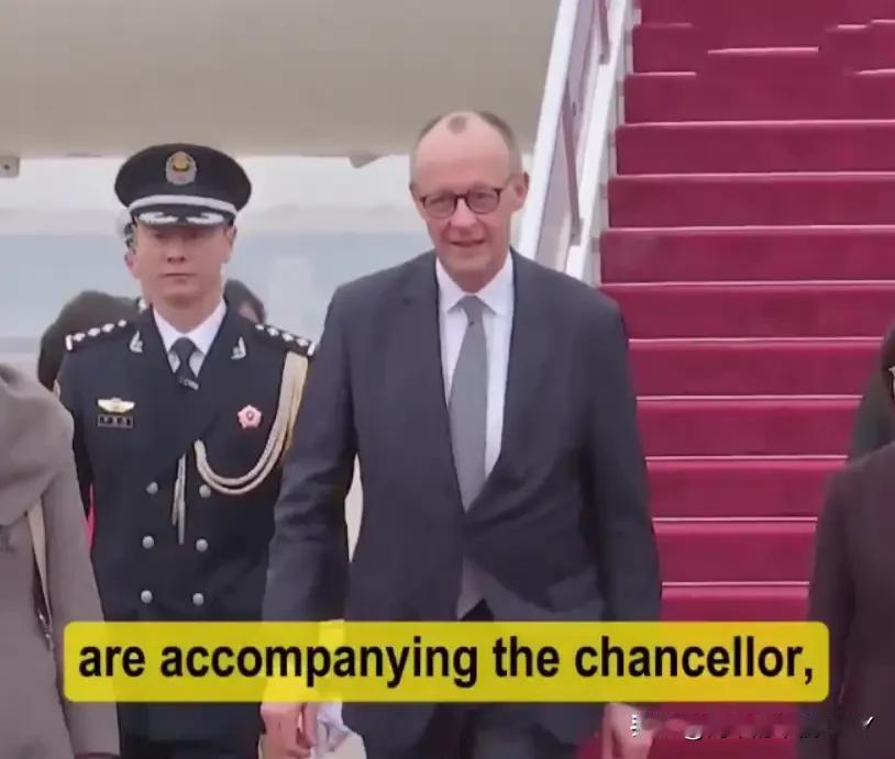 2月25日德国总理抵达访华第一站受到隆重欢迎，走在机场的红毯上，一位穿着军装的兵