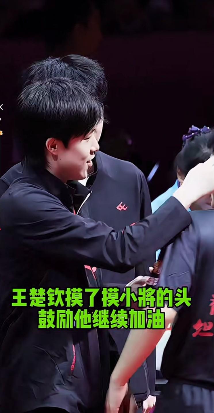 王楚钦摸了摸小将的头，鼓励他继续加油！王楚钦太有爱了，摸了摸小将李天阳的头，鼓励