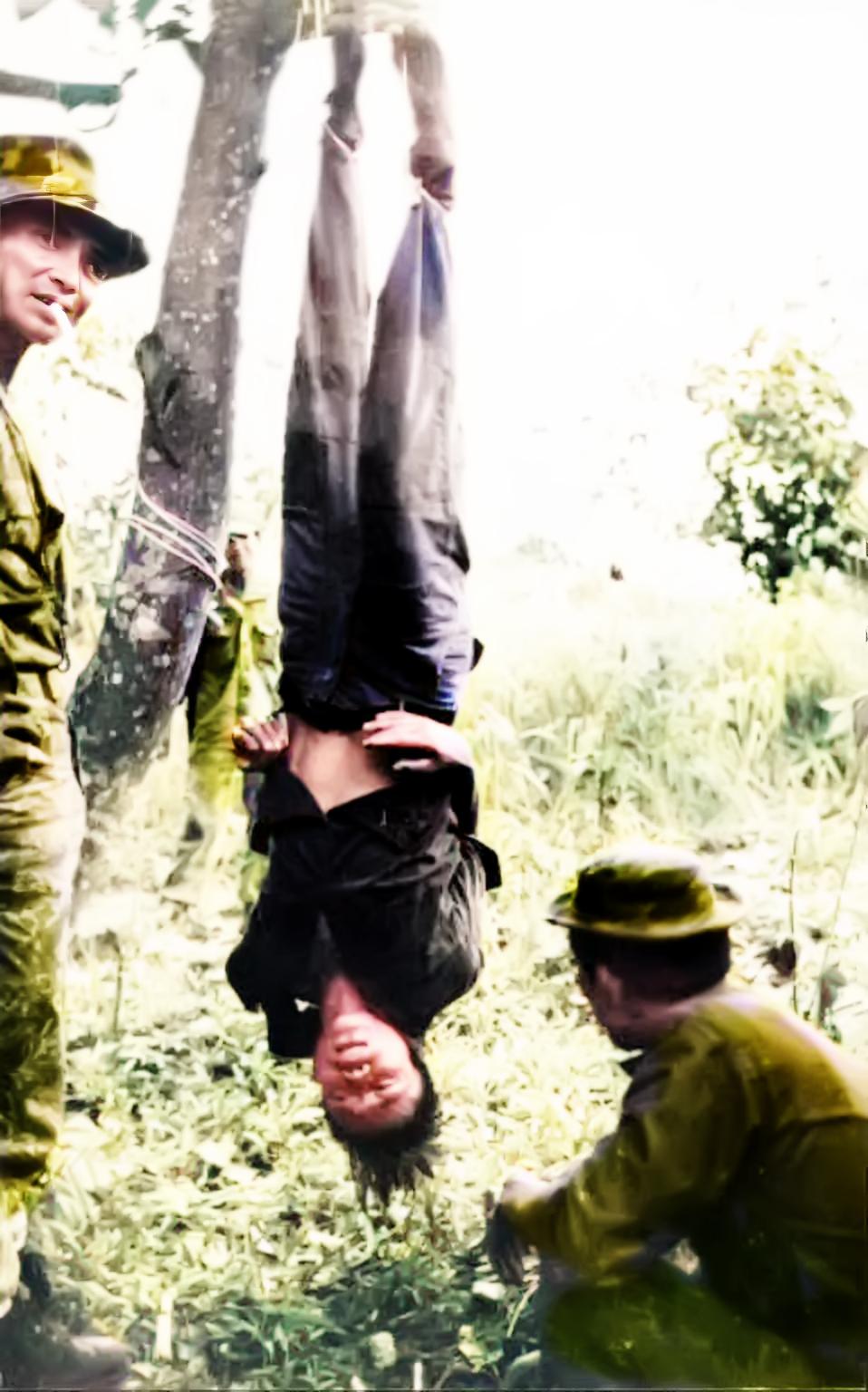 1966年，越南。美国特种兵将一名自愿“援越抗美”的中国年轻人倒挂在树上审讯。