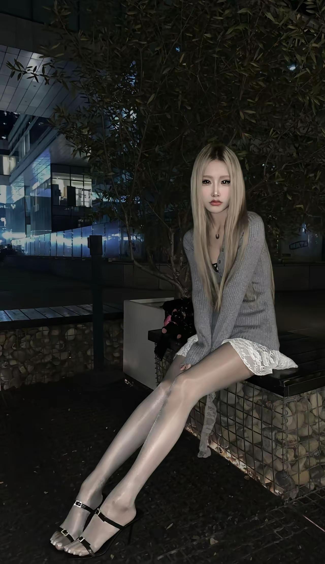 夜晚街头的优雅少女，黑白穿搭尽显时尚感。