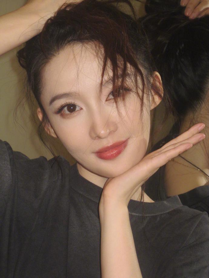李沁自由随性的美李沁放送片场收工随拍，基础款黑T恤简约大方，蓬松凌乱高马尾自带慵