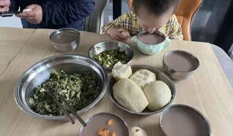 这不是全国80%人的早餐吗这张早餐的照片火了，木头桌子上摆着不锈钢盆装着两青菜