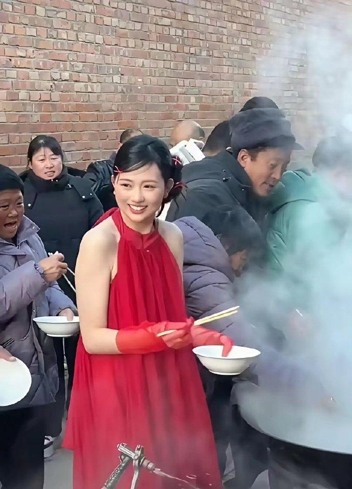 今天见到一个最接地气的新娘：穿着礼服在大锅旁帮大家盛饭。一群人围着大锅排队打