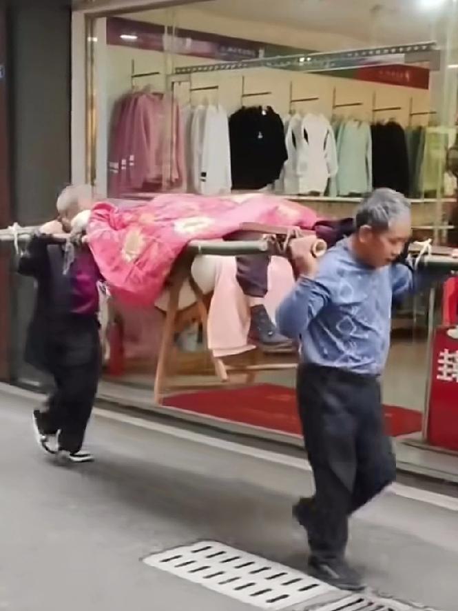 两兄弟抬94岁老娘去医院看病,看完病又抬回家,大哥72岁抬后面二弟快70岁抬前面