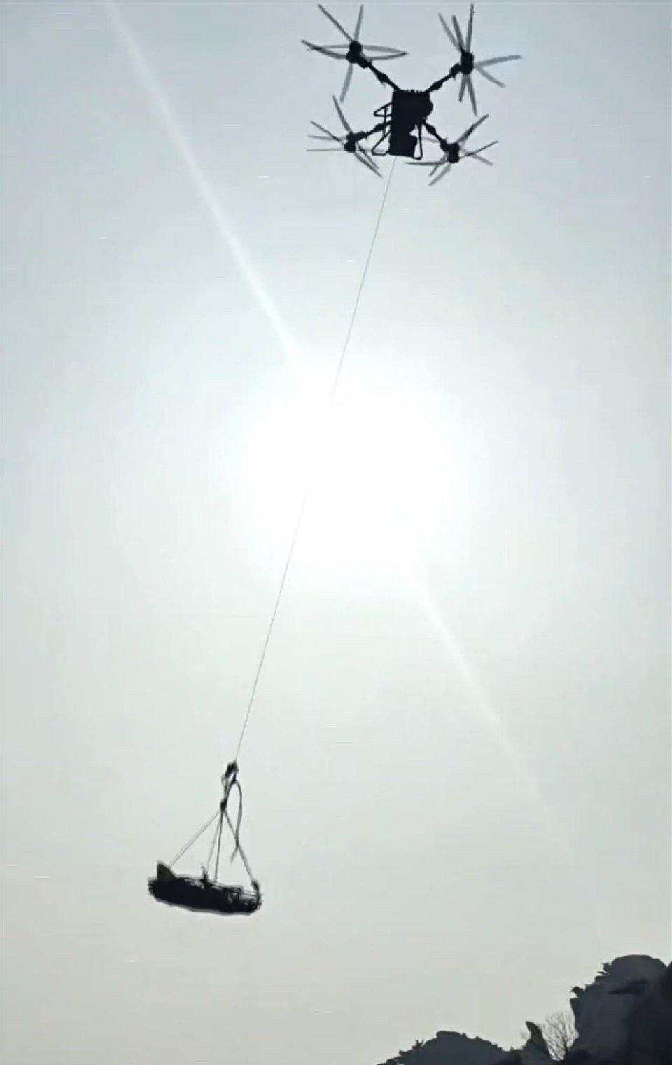 据网友发布视频，一架无人机吊着担架，缓缓从山间升起，担架抬着的是一具遗体。视频还