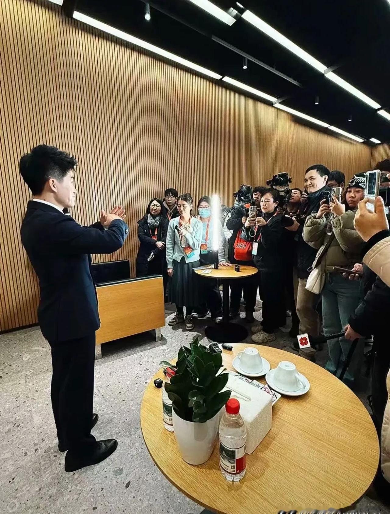 采访结束。六个麦克风同时往董宇辉领口上夹，直接夹爆。你想象一下那个画面：所有