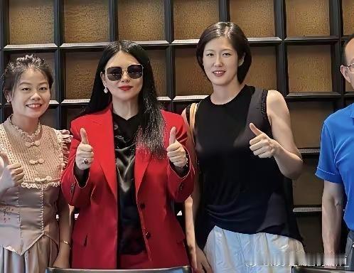李湘与友小聚，一身红西装配红宝钻戒依旧贵妇范儿十足，可惜P图只顾精修脸蛋，身材线