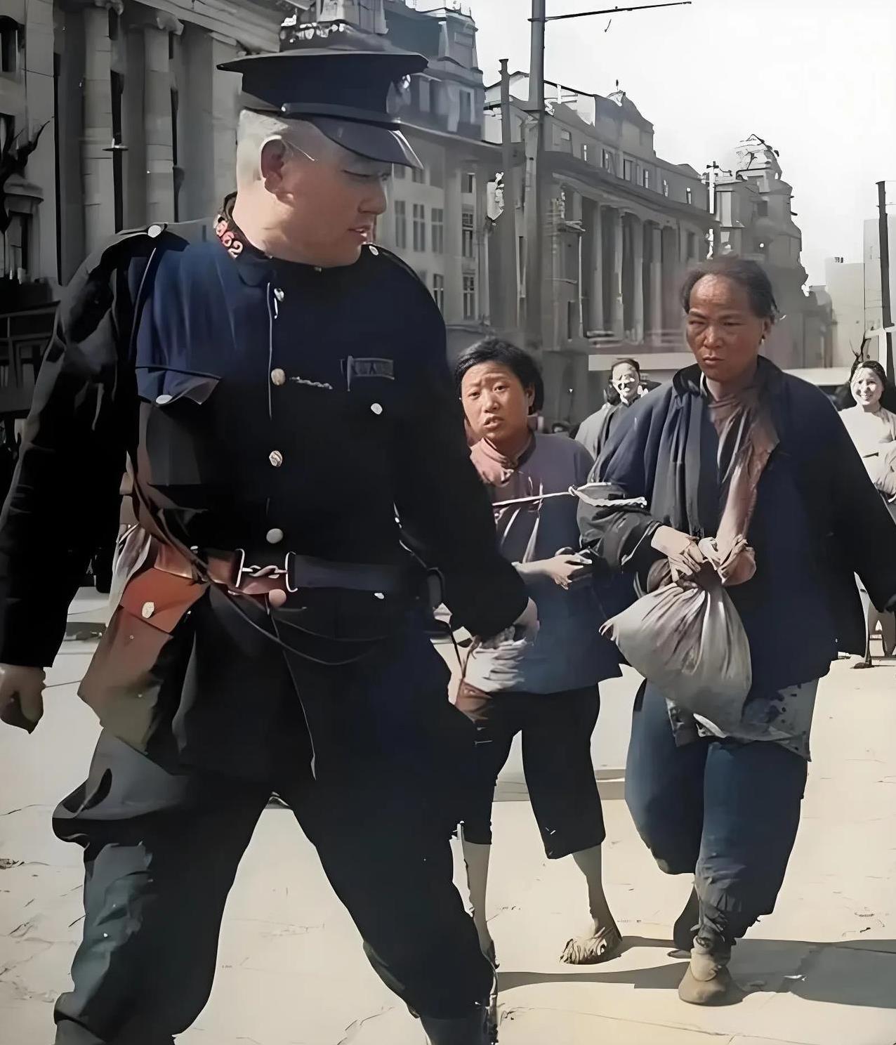 警察抓小偷。1948年，上海。一名肥头大耳的警察捆绑着一对衣衫褴褛的母女，恶狠狠