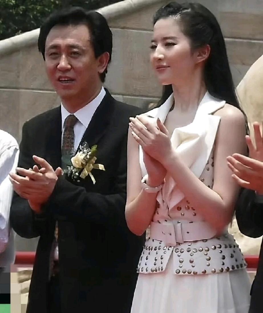 许家印的个子好像不是很高大，他和图片中两位女明星的身高差不多。