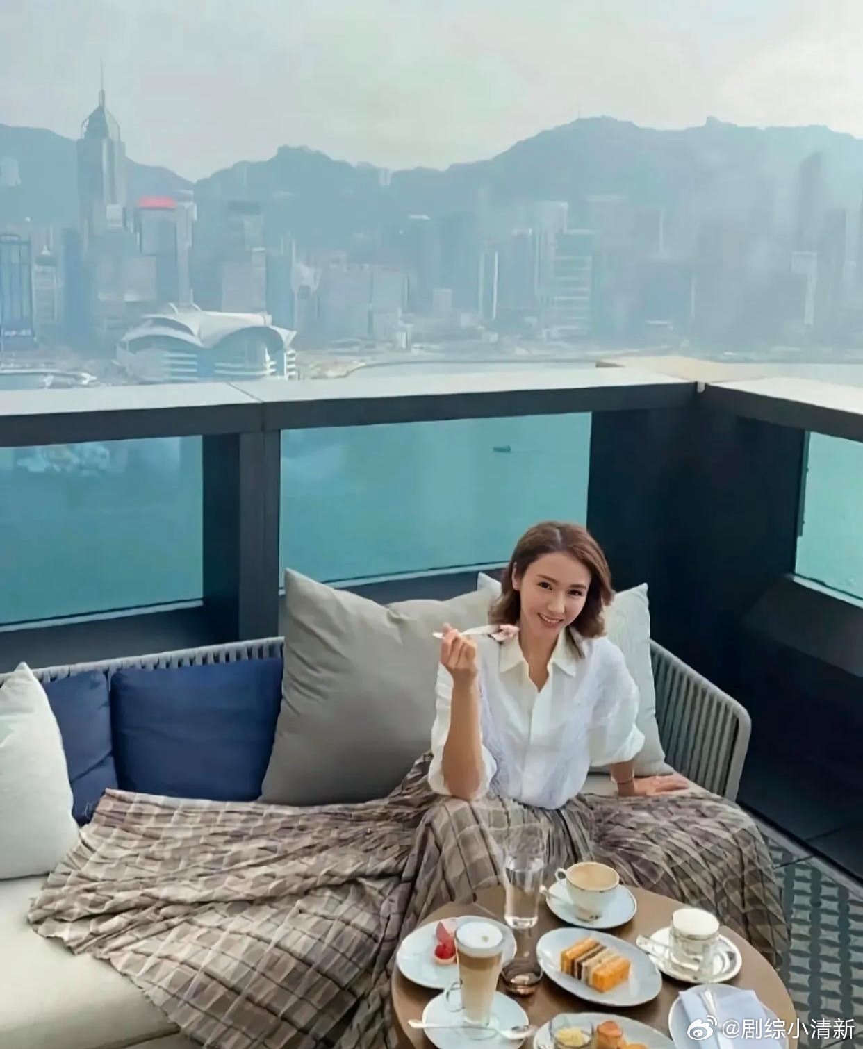 54岁的黎姿，在自家价值数十亿的半山豪宅露台吃下午茶，穿着一件白色衬衫，搭配格子