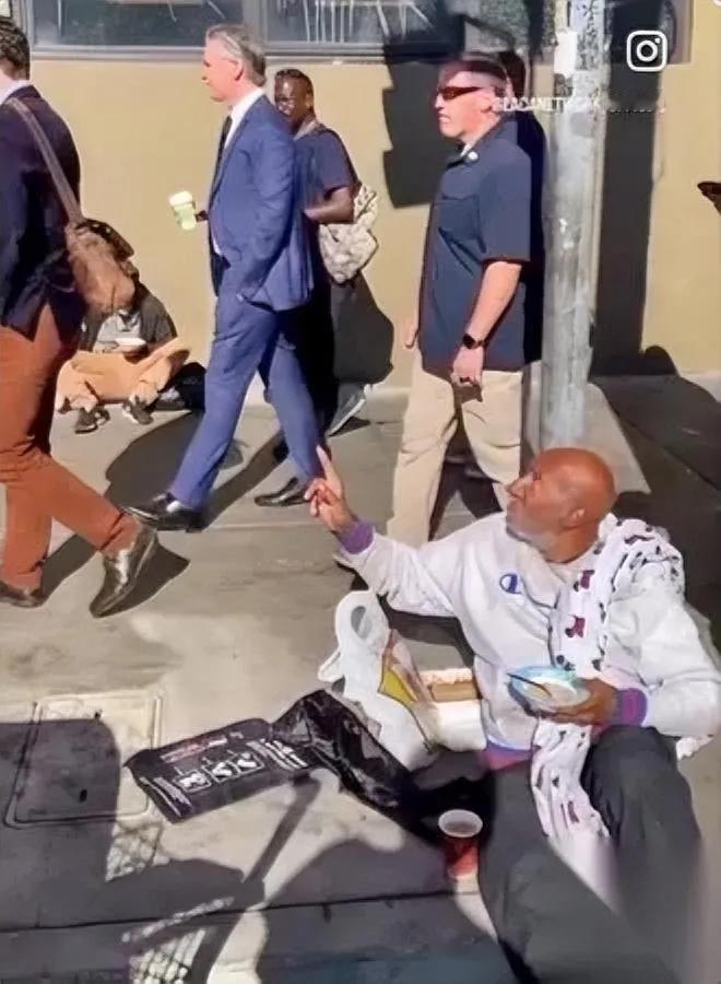 州长咖啡在手，步态悠闲身后流浪汉却活在“斩杀线”纽森插兜走过的加州街头，