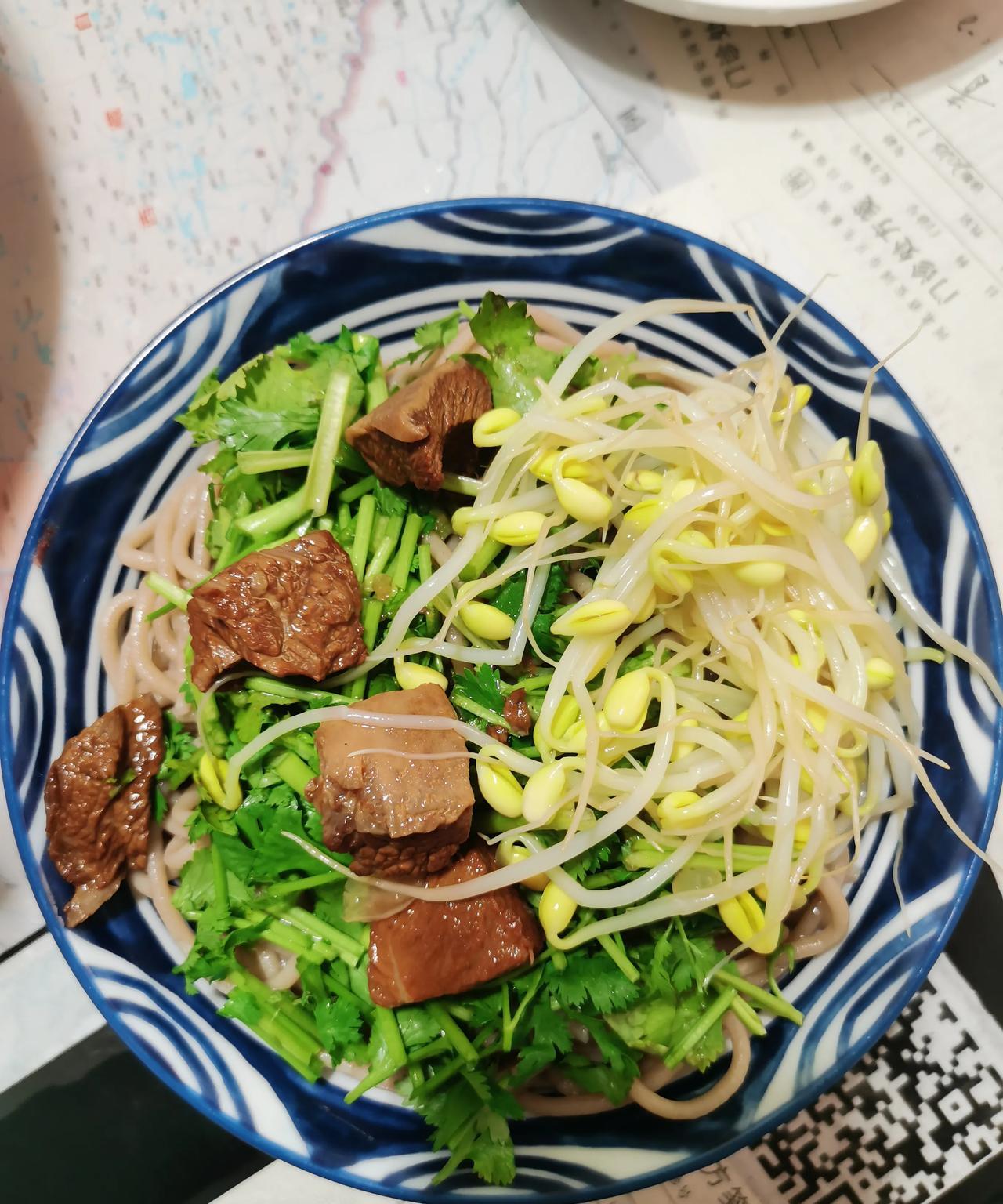 用筱麦面压的饸饹面，黄豆芽菜码，香菜丁。牛肉汤浇上，上面三几块红烧牛肉。[捂脸哭]