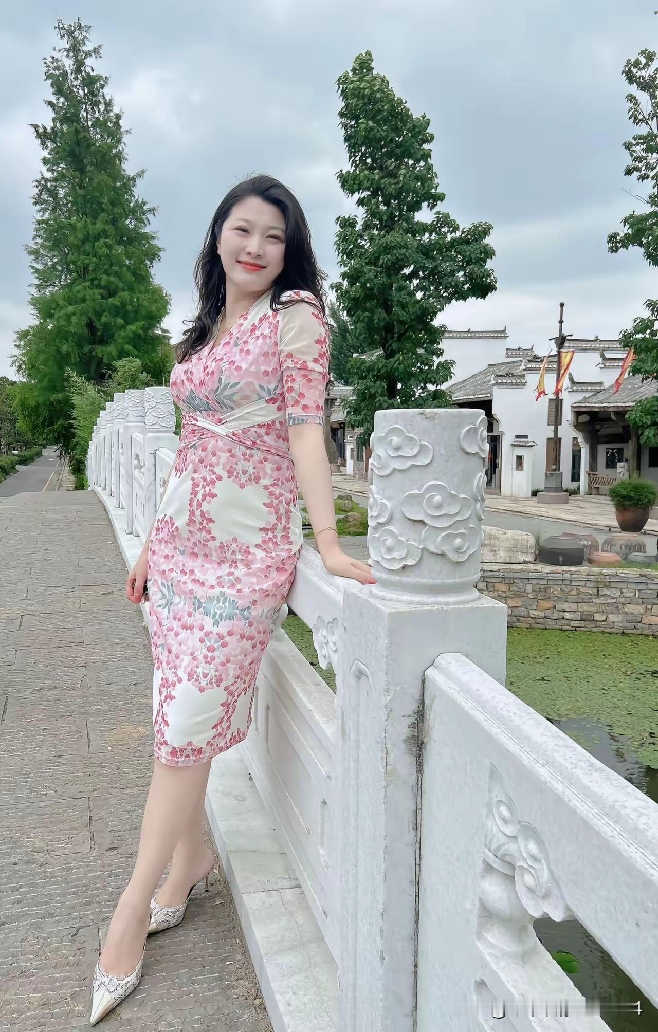 在古风小桥上，穿着粉色旗袍，感受江南水乡的韵味。