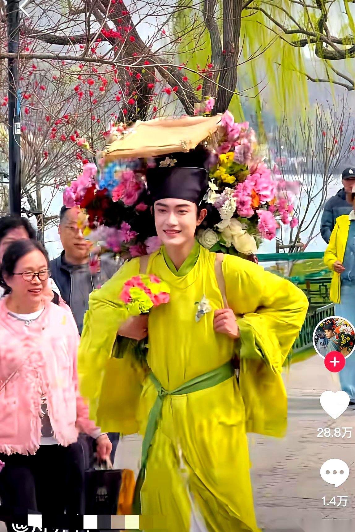 西湖边上，一堆人围着的不是断桥，是个卖花的小伙子。更怪的是，旁边卖花姑娘的摊子