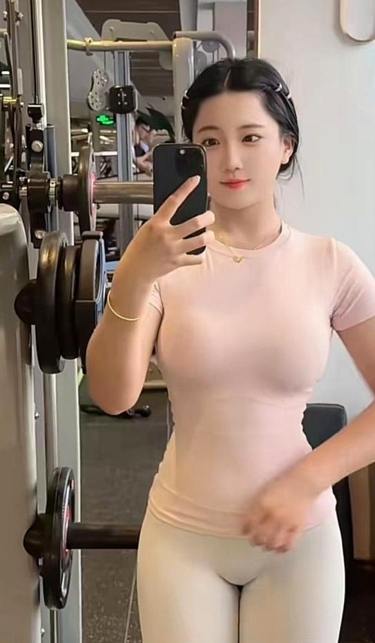 女孩在健身房展示完美身材。