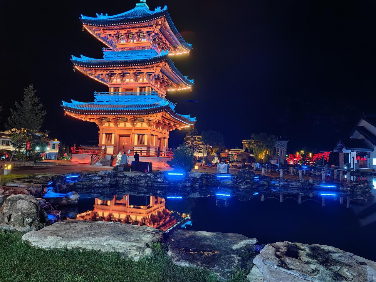 夜幕下的古塔，灯火辉煌，倒映在静谧的湖面上，宛如仙境。