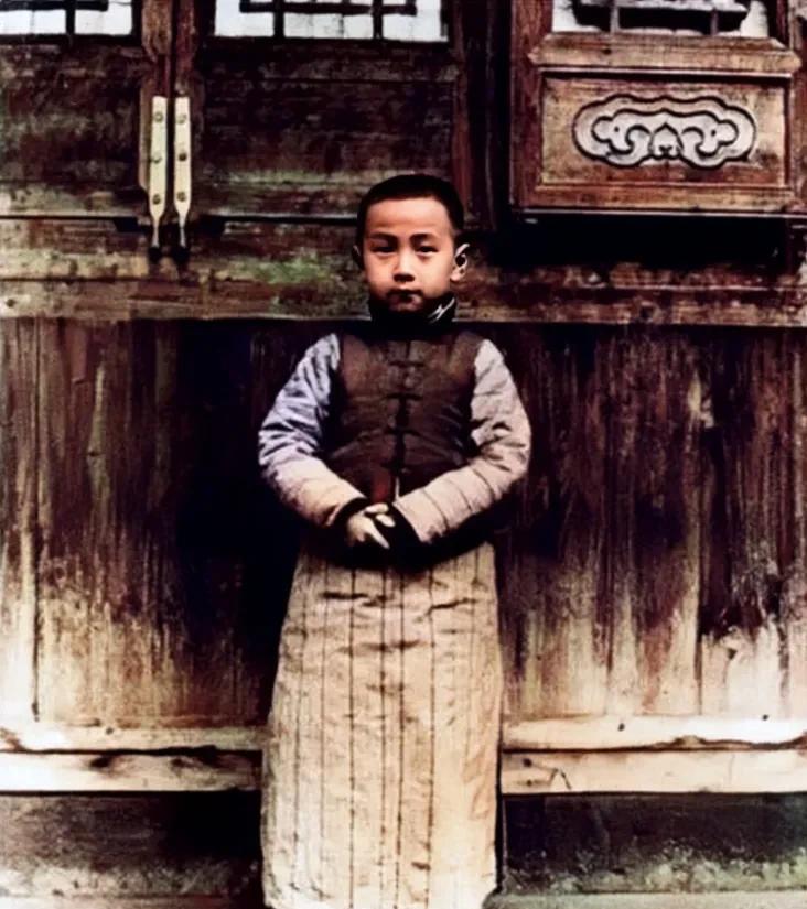 1918年，一位7岁的小男孩站在家门口的留影老照片，照片中的他穿着精致的小衣服，