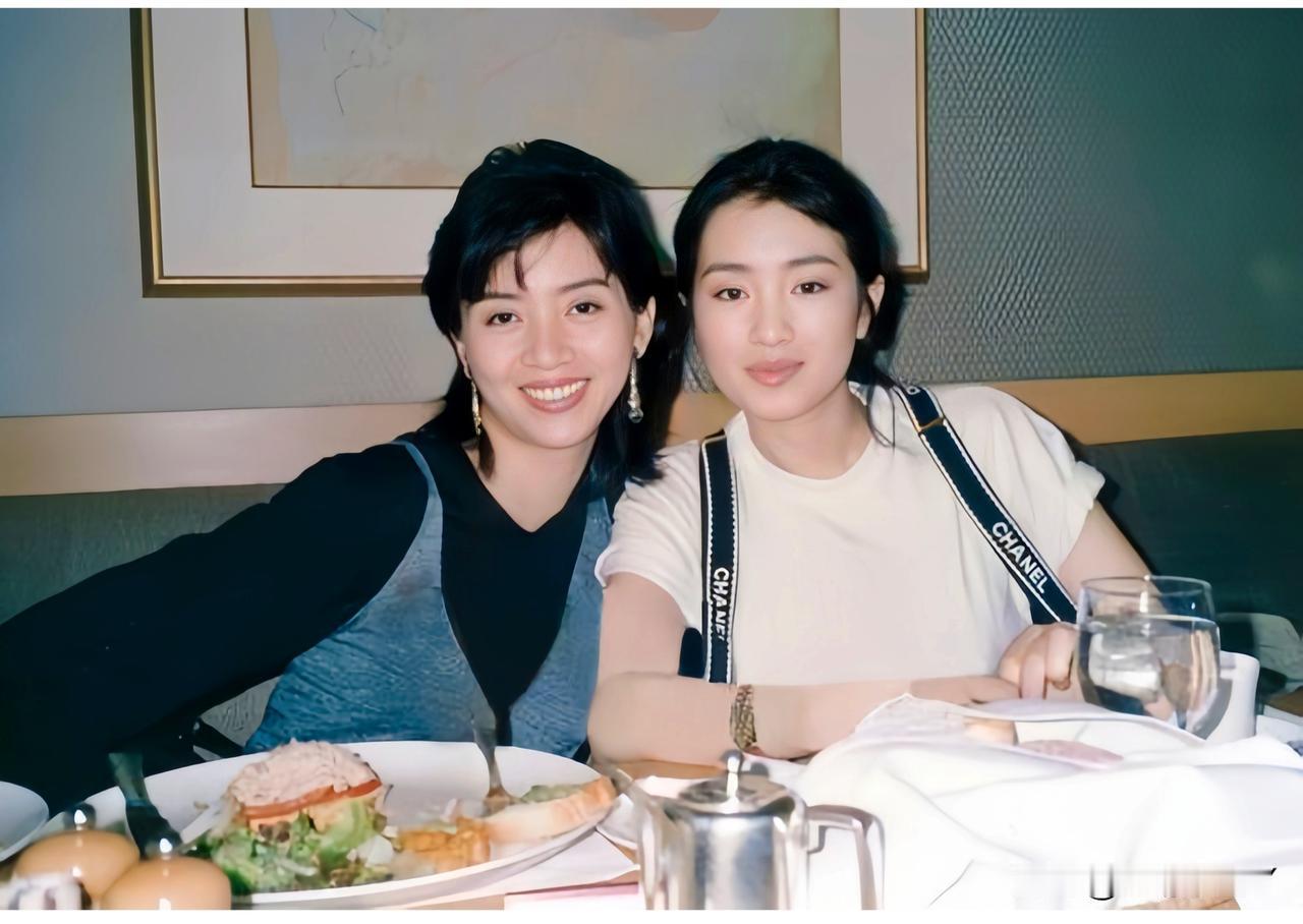 这是1991年巩俐与梅艳芳在餐桌上的合影，当时巩俐26岁，美丽大方。梅艳芳28岁