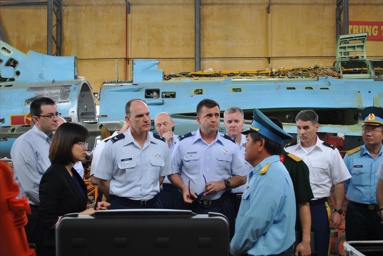 美国空军学院代表团参观越南空军A32工厂，获赠“苏-30"模型,背景是一架翻新中