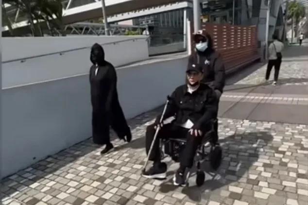 88岁谢贤坐轮椅出行被网友偶遇，两保姆陪伴左右，谢贤戴着黑色棒球帽，墨镜，口罩拉