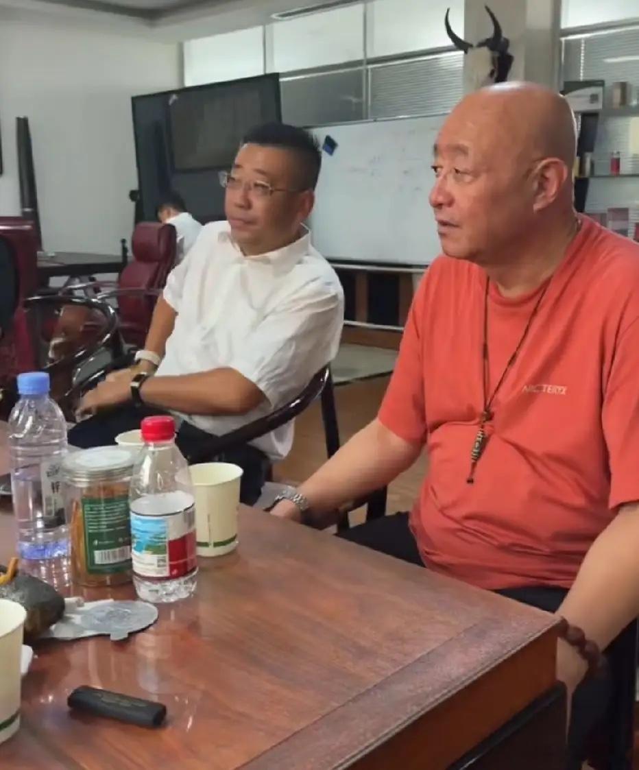 陈寒柏与友人喝茶小聚聊天时的一幕，脖子上菩提类挂坠、左手金属腕表、右手黄花梨深色