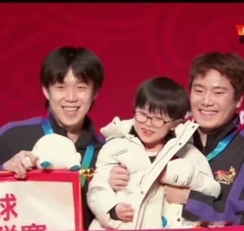 乒超颁奖合影最亮的靓仔是小凉皮。梁靖崑的儿子凉皮，因为被横幅挡住被梁靖崑抱了起