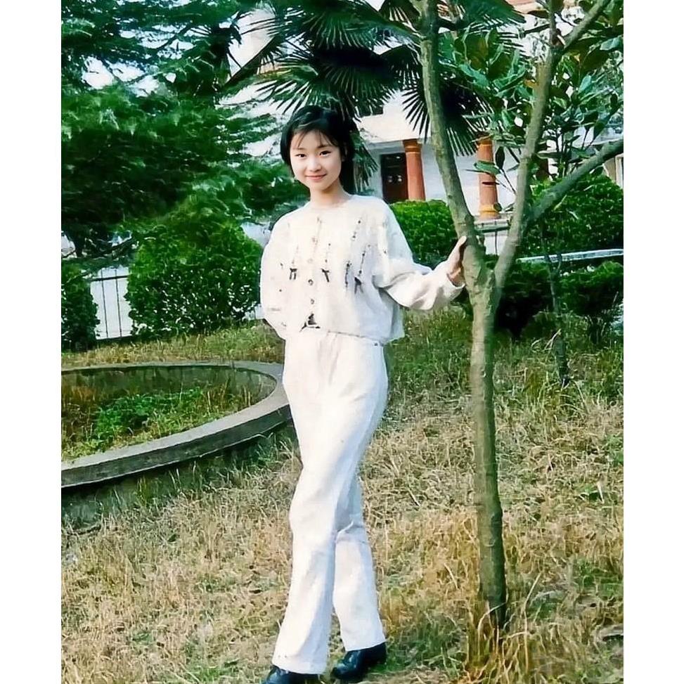 1996年，广州，一位亭亭玉立的少女站立在一棵小树下，当时只有16岁，尽管多年后