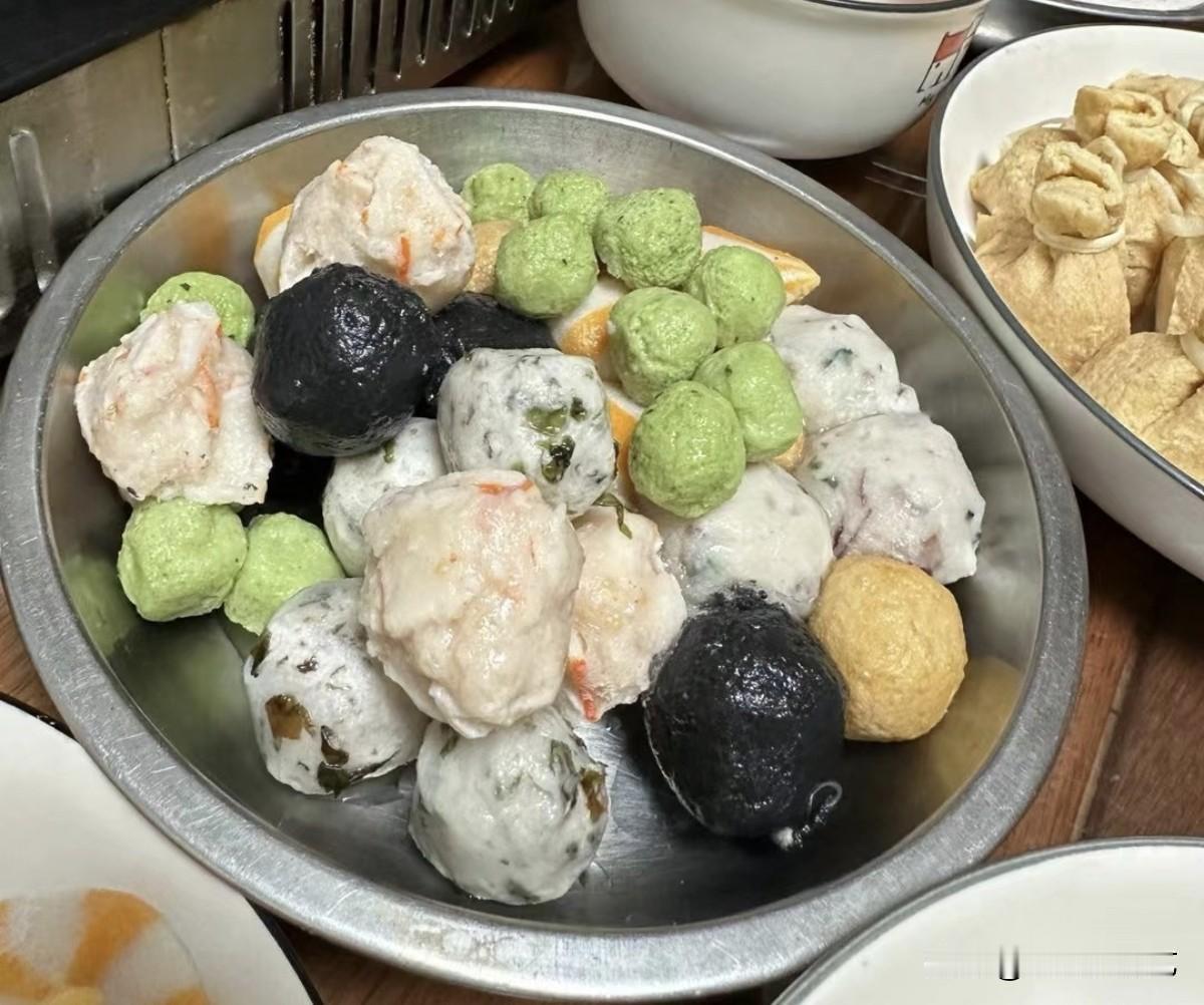 晒图笔记大赛满满一盘各色火锅丸子色彩缤纷，虾丸、墨鱼丸、海菜丸齐聚一堂。墨黑、嫩