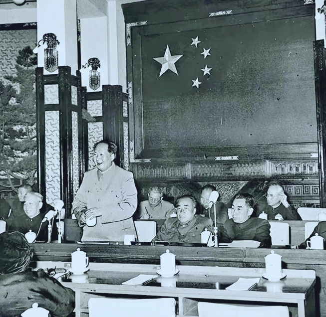 1956年，毛主席在一次大会上讲话，他站着讲话，笑容满面。他左边右边分别是刘