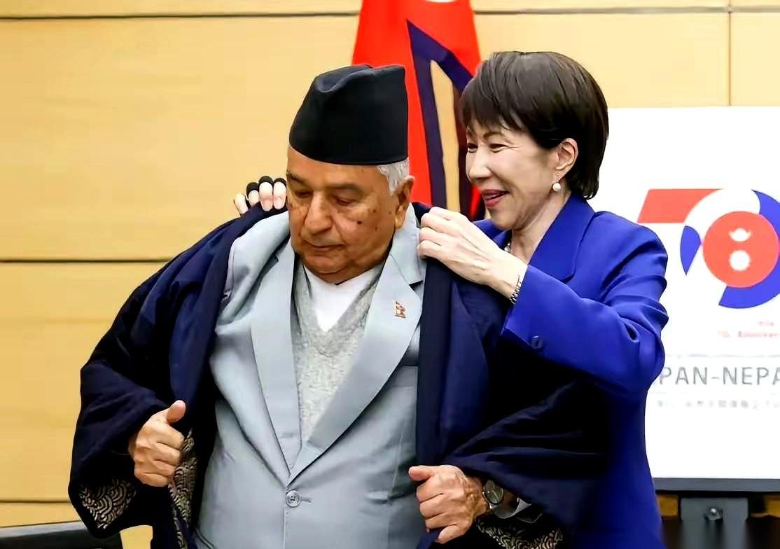 真的，我隔着屏幕都替她累得慌。亲自上手，弯着腰，给别国总统穿大衣。那笑容，跟