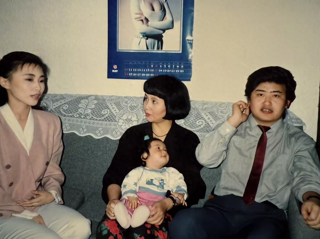 1992年，刘欢和妻子卢璐，女儿刘一丝在家里的合影，刘一丝才8个月大，还在母亲怀里抱着。刘欢穿着衬衣