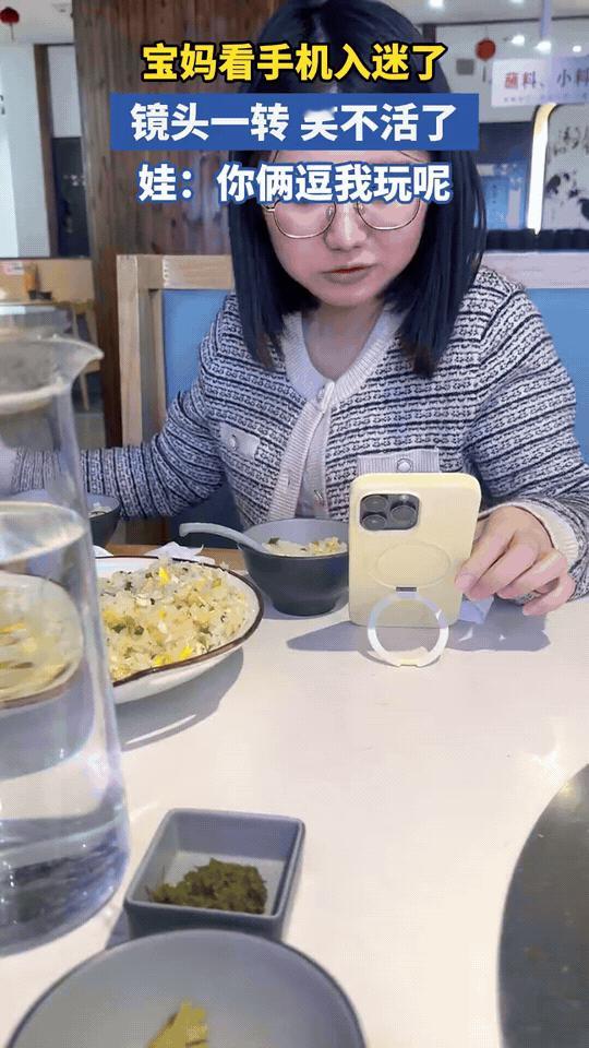 宝妈吃饭刷手机入迷，喂娃喂了个寂寞，娃一脸懵：你逗我玩呢？在餐厅吃饭时，宝