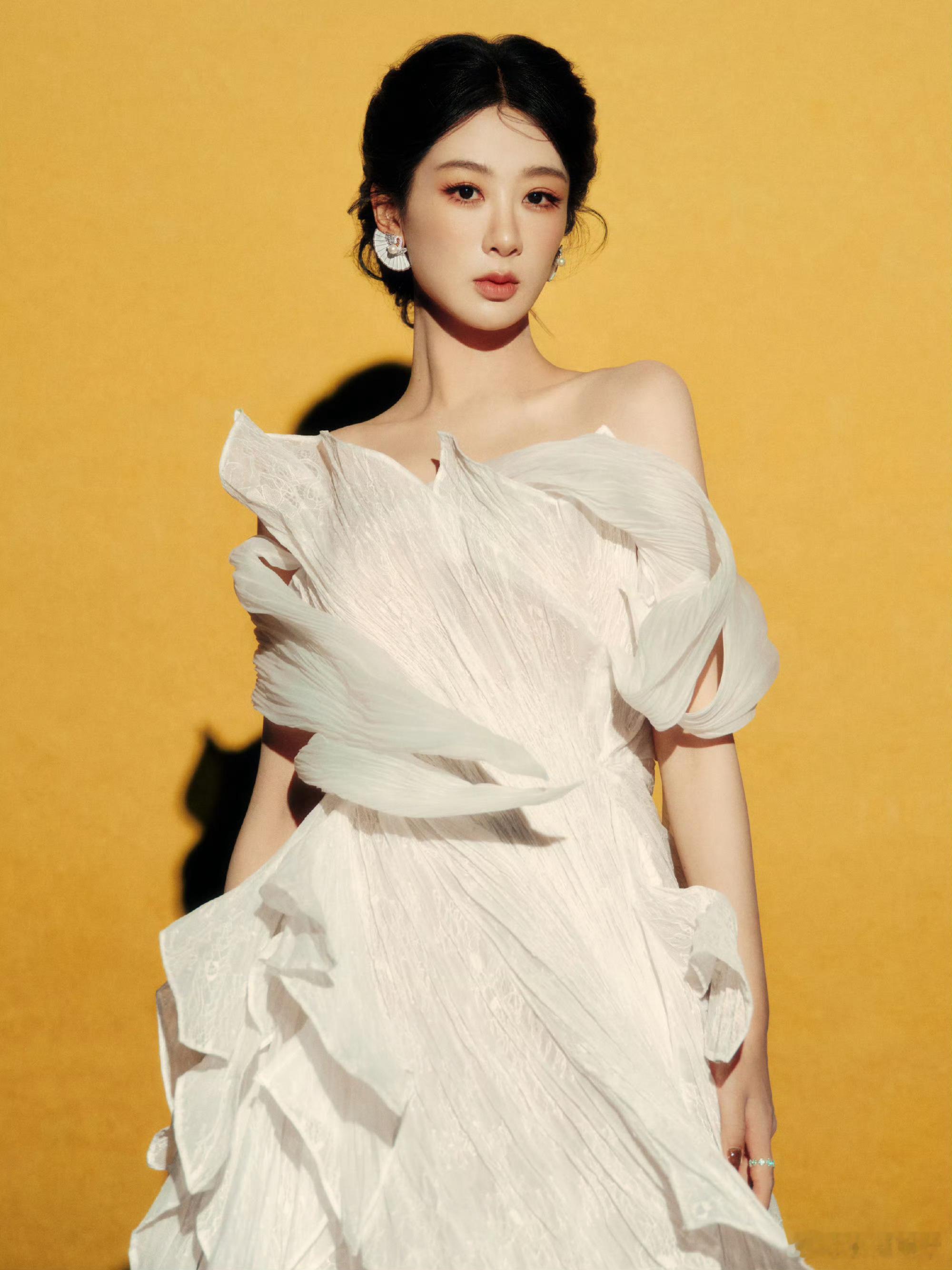 杨紫薄纱白裙造型杨紫一袭薄纱白裙亮相活动，裙摆轻纱飘逸似月光笼罩，简约剪裁勾勒