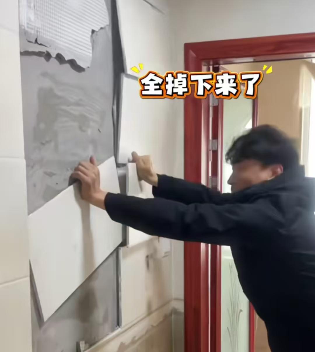 河南一男子验收新房內瓷砖，结果轻轻一掰开一块，整面墙上的瓷砖全掉下来了。有网友评