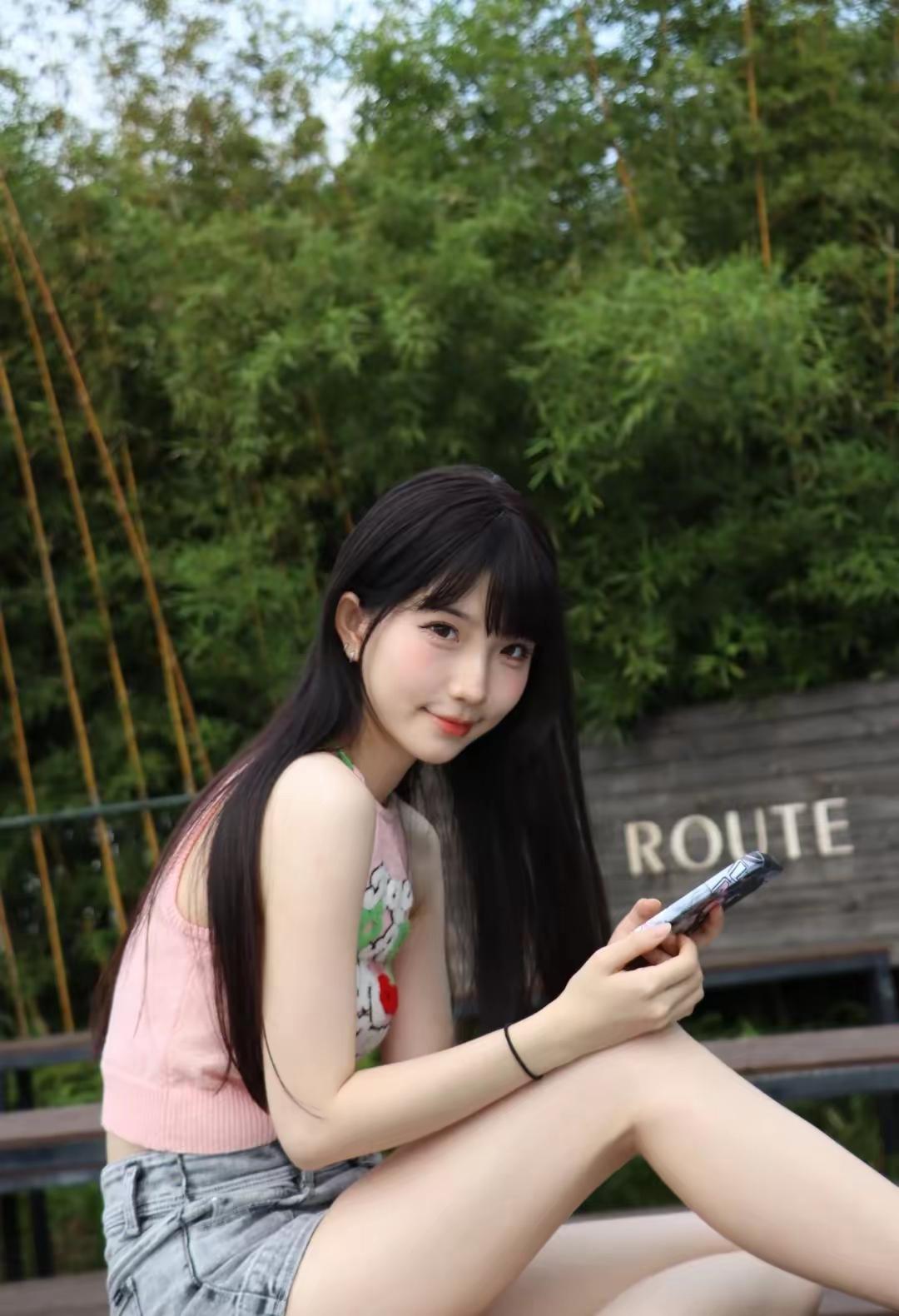 竹林深处，少女轻抚手机。