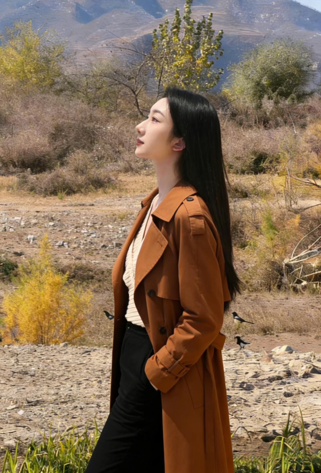 目光越过枯黄的草甸与远山的轮廓相融焦糖色风衣裹着风她站成，秋山的一部分