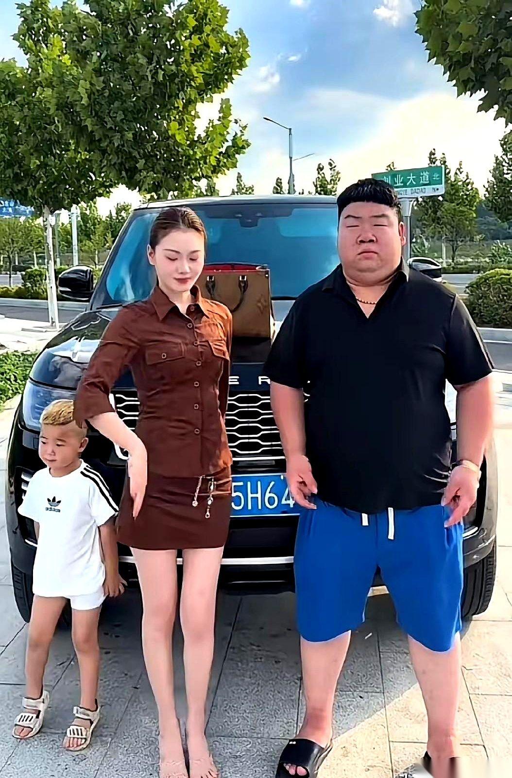 200万的顶配大揽胜横在马路牙子上。车前头，老婆穿着超短裙、露着大长腿，手里明