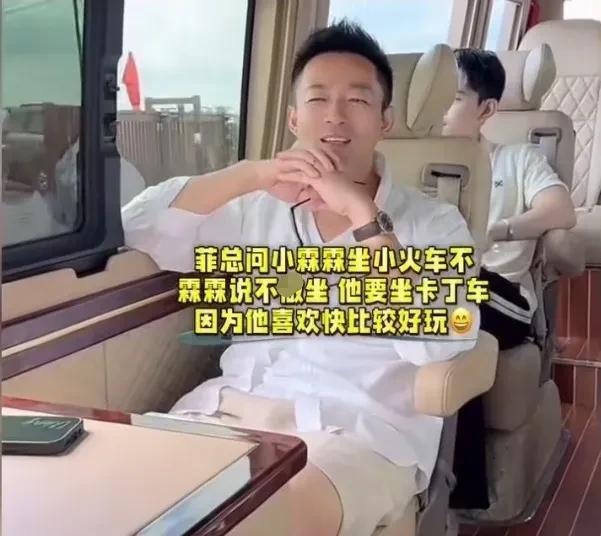 汪小菲一家子同坐在一辆车上，小霖霖看着窗外的风景，高兴的问汪小菲说：“爸爸，这不