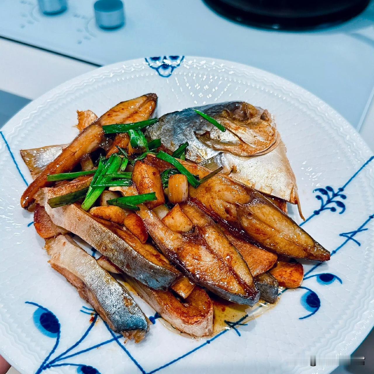 从煎得金黄的鱼块，到锅里淋上酱汁、撒上葱段咕嘟着香气，最后盛到带着蓝纹的盘子里—