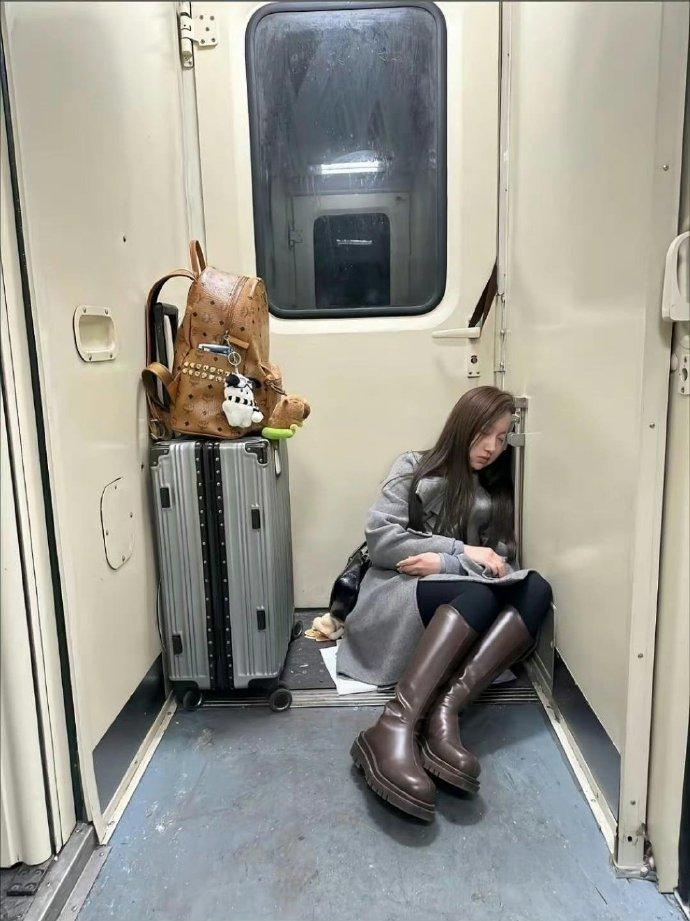 在火车上看到这一幕，瞬间破防了。姑娘拎着大包小包，在车厢角落的地上坐着就睡