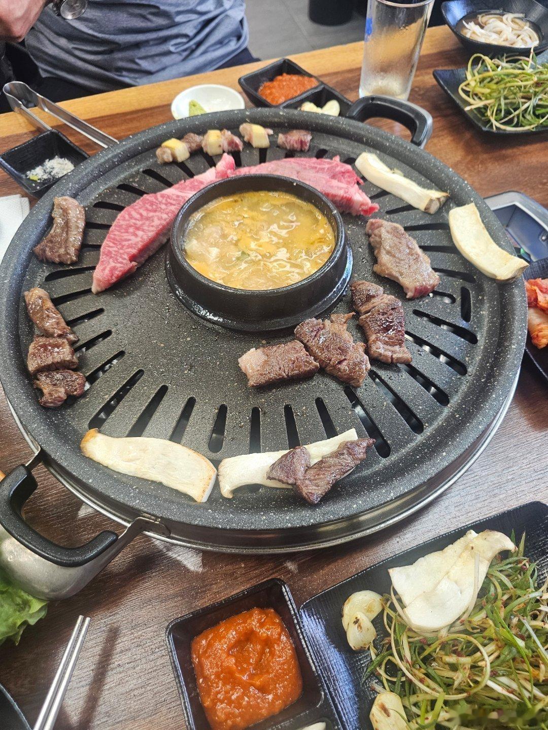 WEKaris发布与家人外出聚餐照片，画面展示烤盘上的牛肉、菌菇及各式配菜，氛