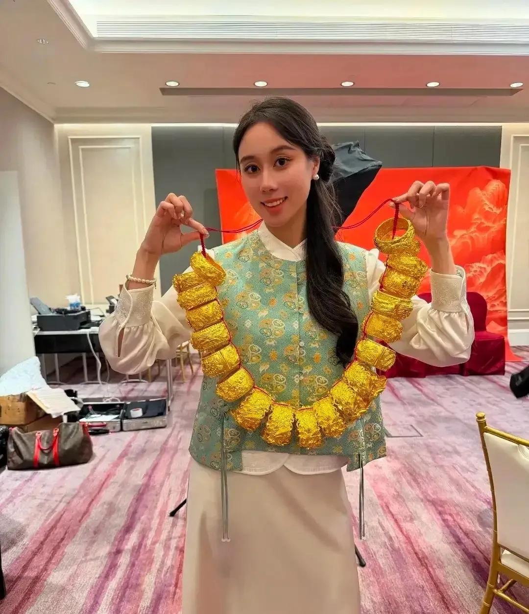 奚梦瑶在澳门答谢宴上佩戴的黄金手镯，应该很轻，何超亲用小红绳就可以轻松把20个黄