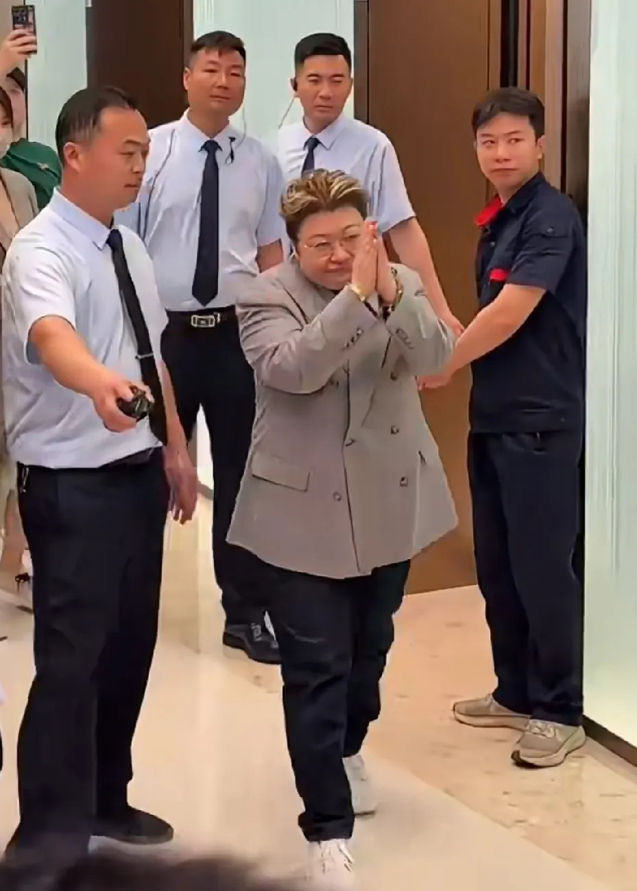 韩红出席线下见面会时的一幕，前呼后拥，双手合十向粉丝们深鞠躬，露出手上戴的金表、