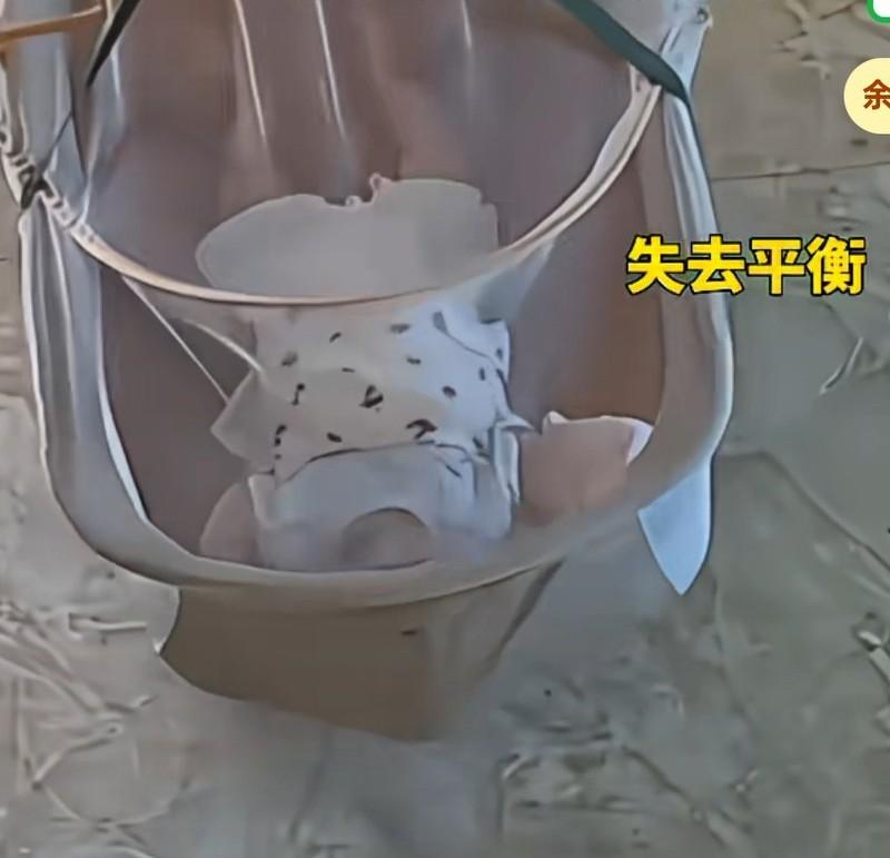 妈妈去做饭，把孩子放在电子摇床上，孩子失去平衡，身体和头几乎折叠，但是电子摇床