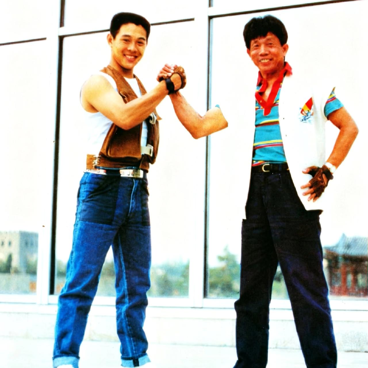 1986年，刘家良和李连杰，一张罕见的合影，照片中的他们并肩而立，紧握对方的双手