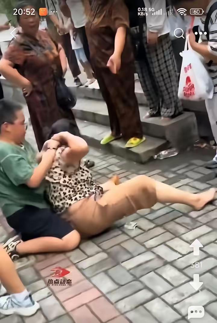 在校口门，奶奶接孙子放学，孙子要买零食，奶奶没有答应，孙子暴怒，上去一把抓住奶奶